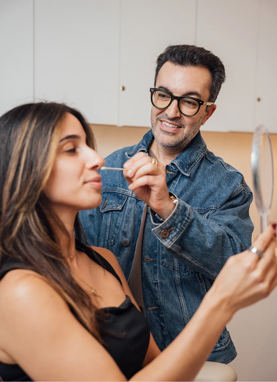 Dr. Moradzadeh, wearing a jean jacket, shown examining a patients nose with a cotton swab. - Expect in Santa Barbara, CA