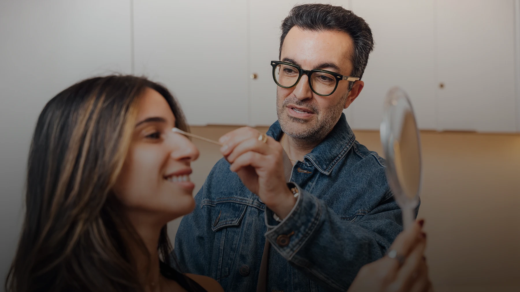 Dr. Moradzadeh, wearing a jean jacket, shown examining a patients nose with a cotton swab. - Nose in Santa Barbara, CA