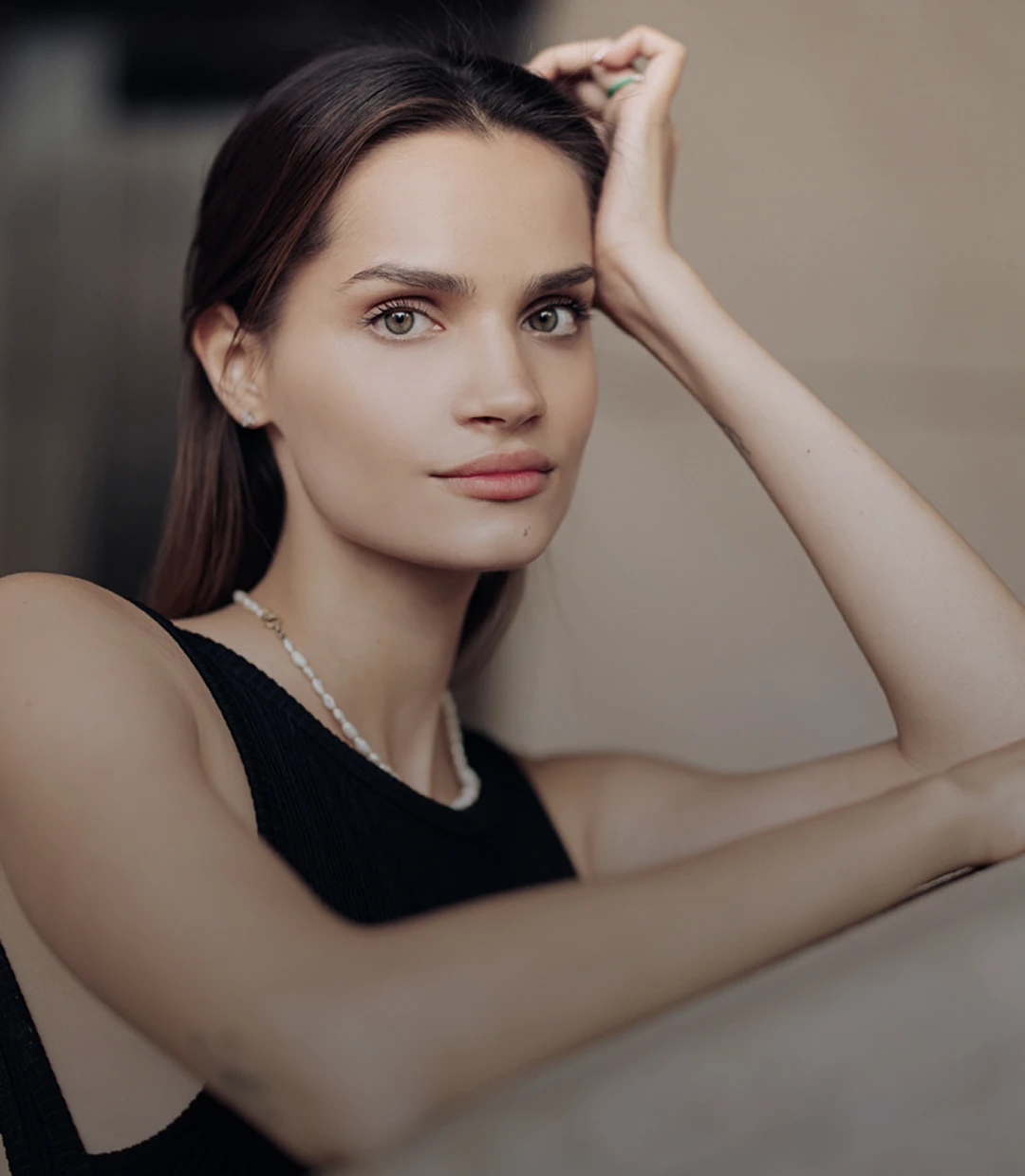 A women in the center of the photo wearing a small pearl necklace and a black tank top. She looks directly in the camera and straight brown hair and hazel eyes. - Home rejuv in Santa Barbara, CA