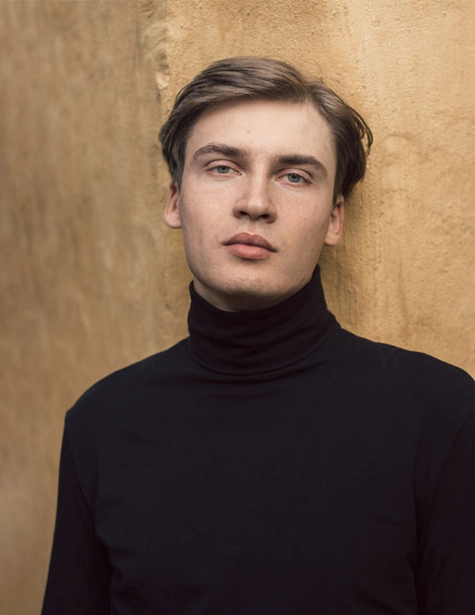 The man looks into the camera. He has blue-green eyes and short brown hair. He is wearing a black turtle neck. - Keraduo in Santa Barbara, CA