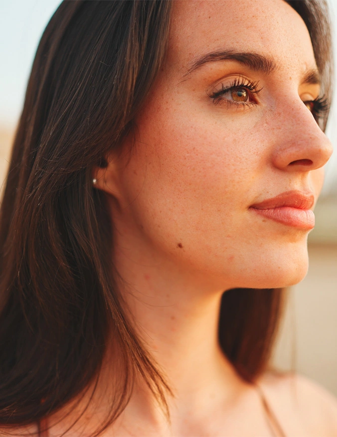 A close up image of a women facing to the right of the image. She has light brown eyes and brown hair. - Sinus surgery in Santa Barbara, CA